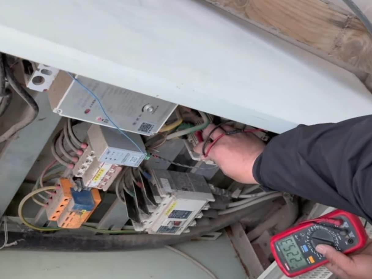 Multimeter testing inside inverter cabinet